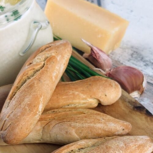 parmesan and herb breadsticks on a wooden board