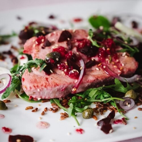 Tuna Steak Salad with beets, capers and mangetout on a white plate