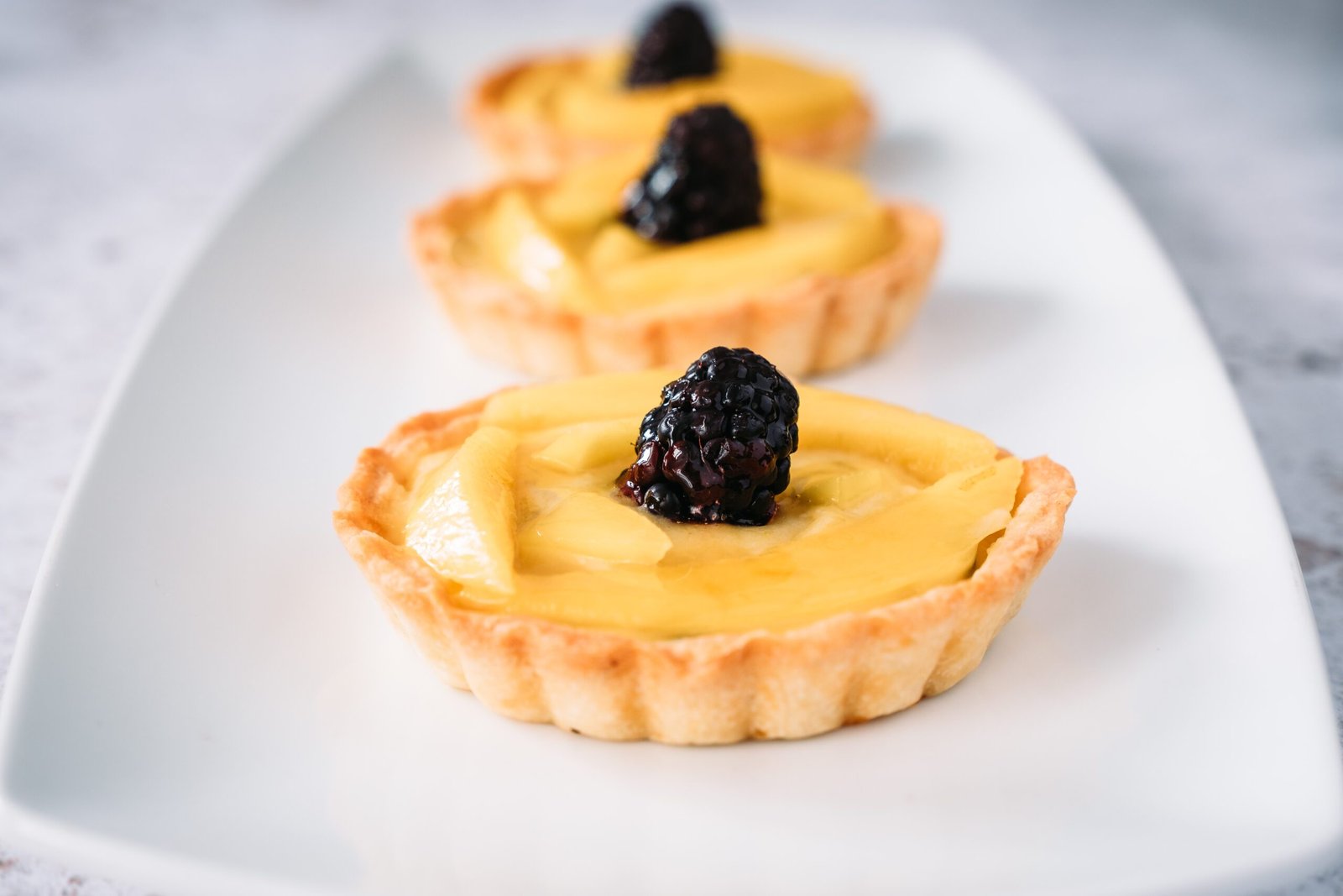Lime and Mango Tarts on a white plate for Food Recipes on Maison Bonhomie