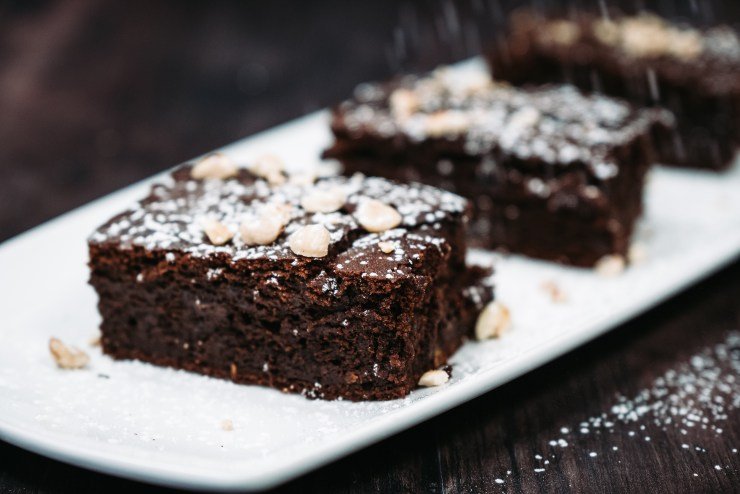 Decadent brownies on a plate dustd in icing sugar