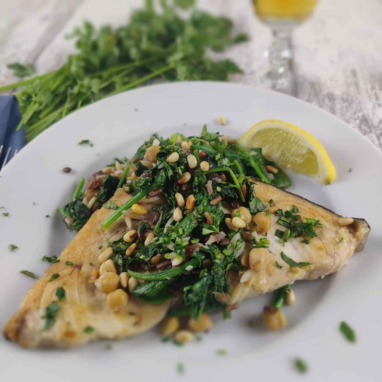 Grilled Swordfish with Rice Pilaf and toasted pine nuts on a white plate