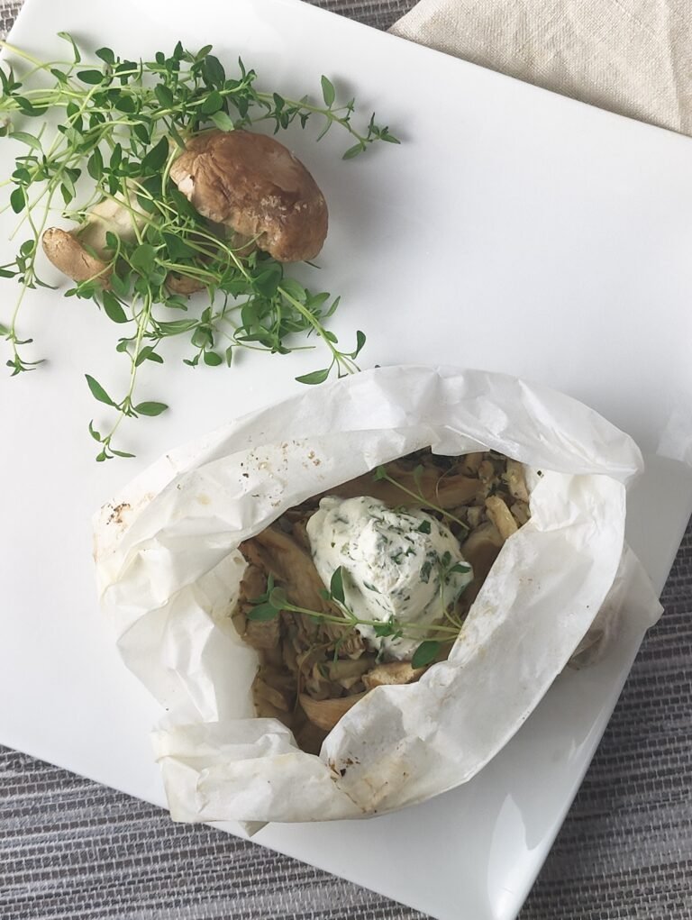 mushroom and thyme parcels on a white side plate with salad garnish