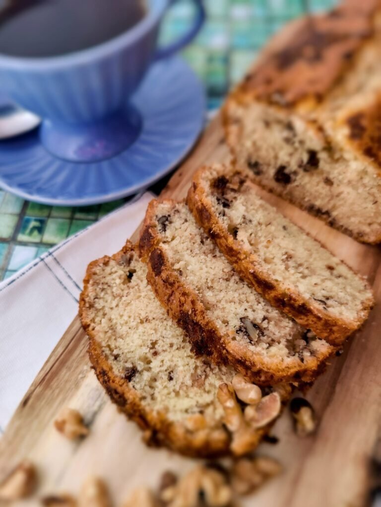 Banana loaf cake [bananabread] on a wodden board with a cup of coffee