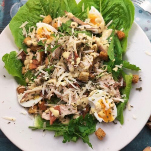 Caesar Salad with Chicken and Bacon on a white plate