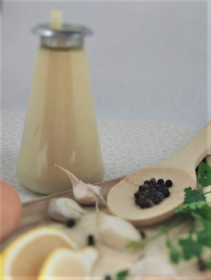 Caeser salad dressing with lemon, garlic and peppercorns on the side