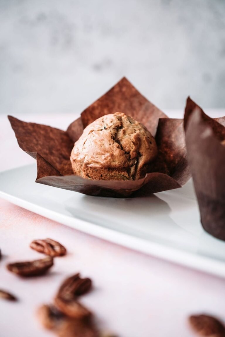 pumpkin muffins in a brown wrapper on a white plate