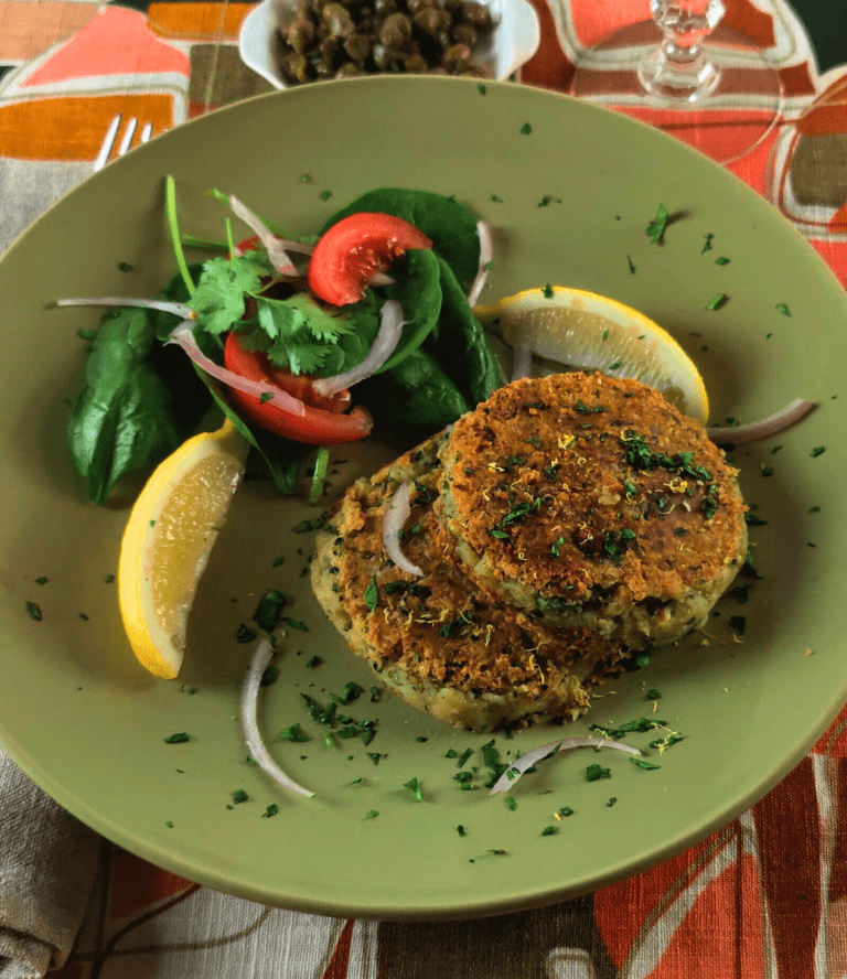 smoked haddock fishcaakes on a green plate with a salad garnish