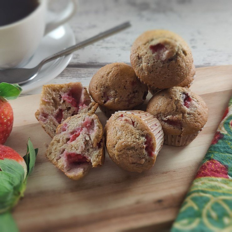 close-up of freshly baked strawberry muffins showcasing their golden-brown tops and juicy strawberry pieces