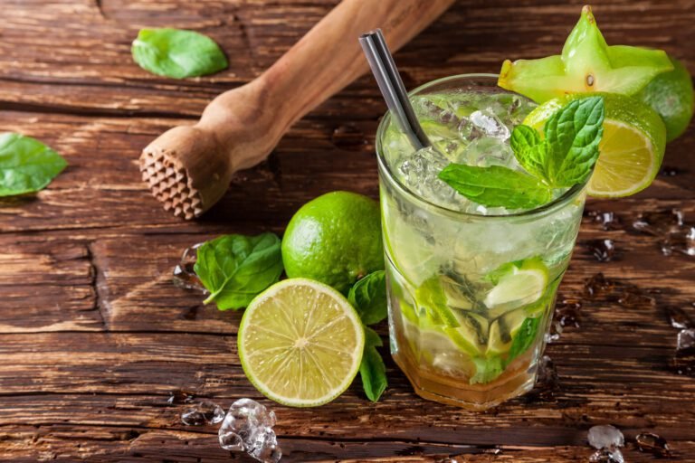 Mojito cocktail in a tall glass with fresh limes *