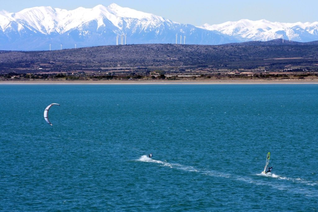 soaking up the sun on a mediterranean beanc in Leucate with mountains in background