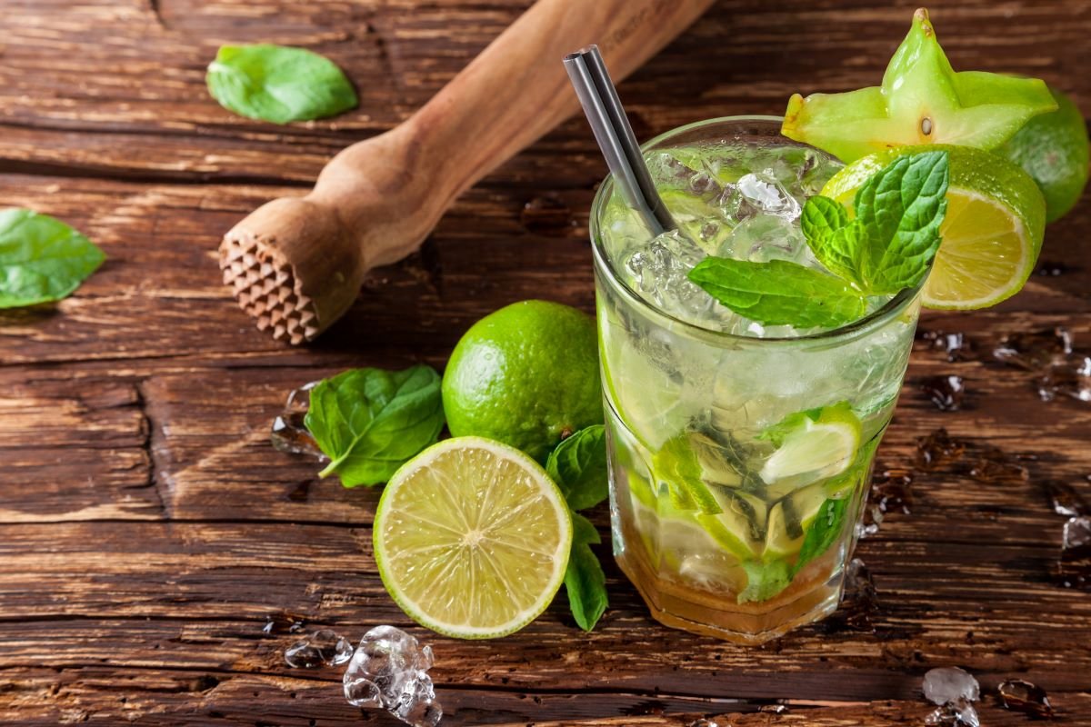 Mojito cocktail in a glass with ice, lime and mint