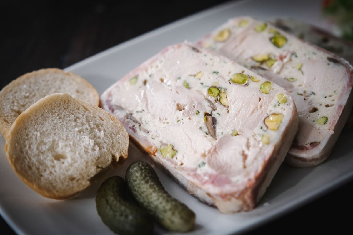 chicken terrine with a baguestte and cornichons on a white plate for FOOD RECIPES on Maison Bonhomie