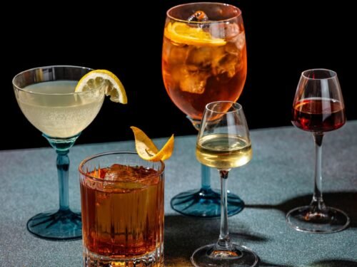 a selection of apertifs and digestifs with garnish on a dark background