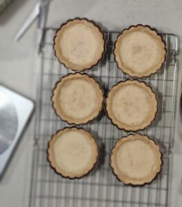 cooked pastry cases on a wire cooling rack ready to be filled with cranberry curd